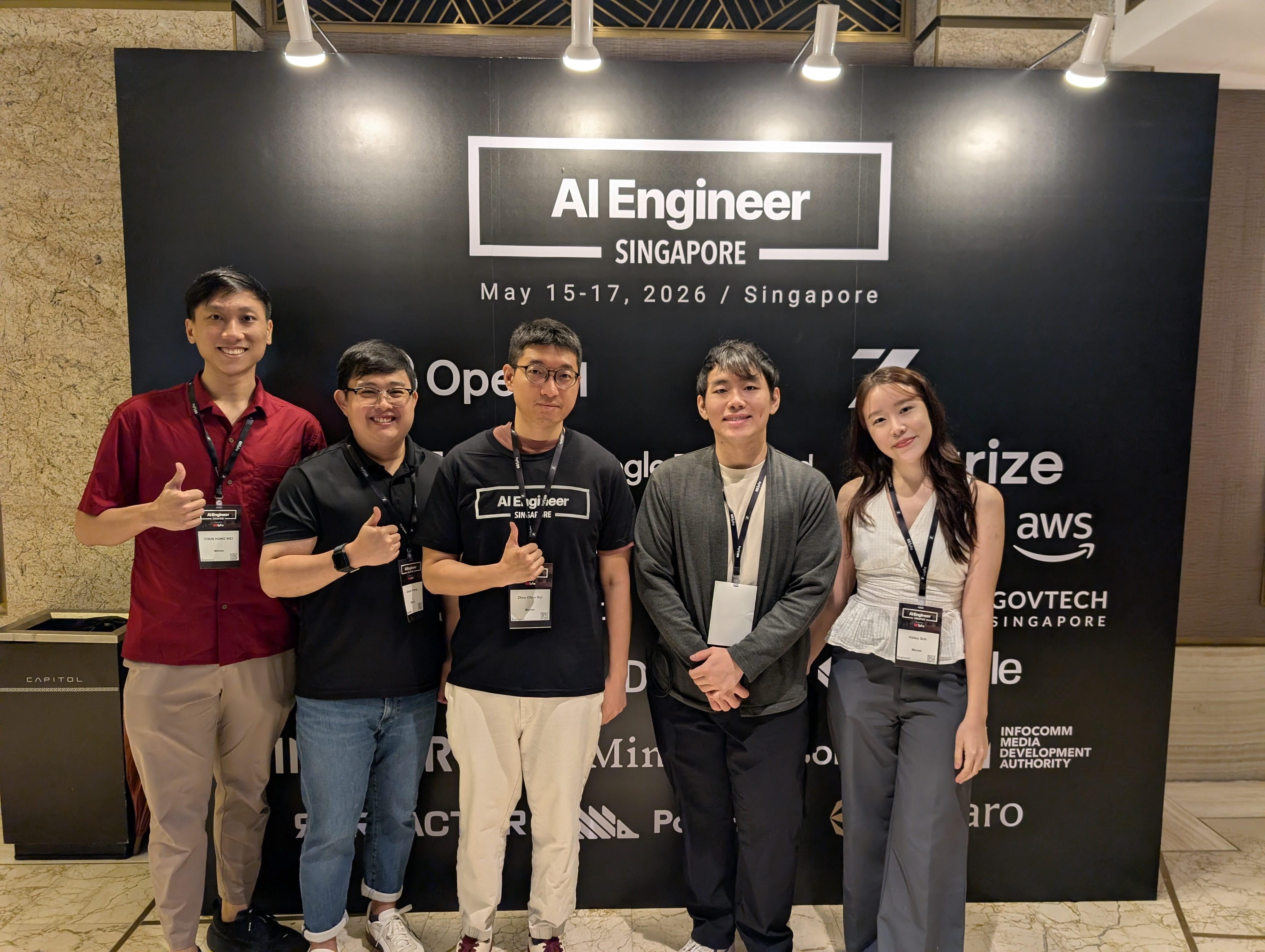 At AI Engineer Singapore 2026 with other attendees in front of the conference backdrop